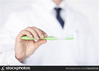close up of male dentist or stomatologist holding toothbrush..
