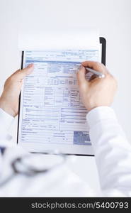 close up of male doctor holding prescription paper in hand