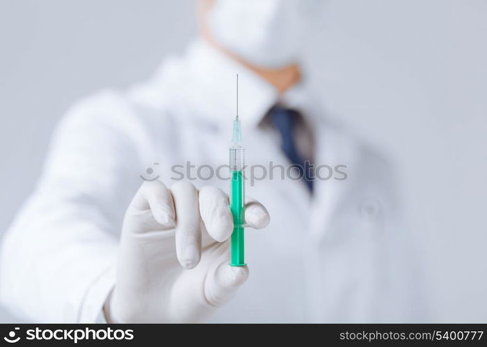 close up of male doctor holding syringe with injection