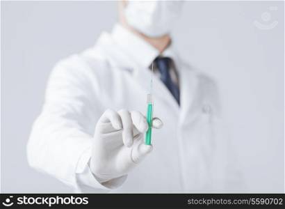 close up of male doctor holding syringe with injection