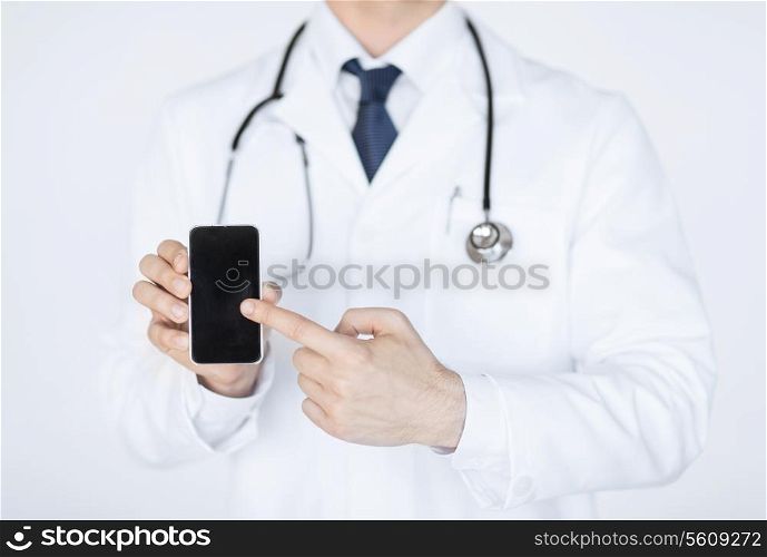 close up of male doctor pointing at smartphone