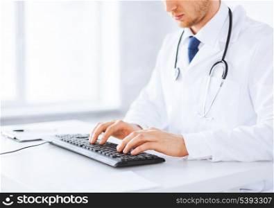 close up of male doctor typing on the keyboard