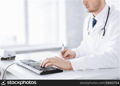 close up of male doctor typing on the keyboard