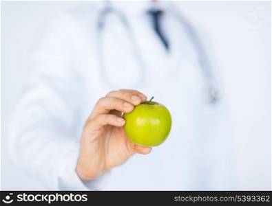 close up of male doctor with green apple