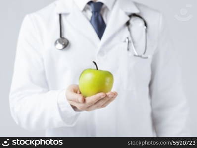 close up of male doctor with green apple