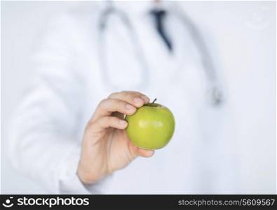 close up of male doctor with green apple