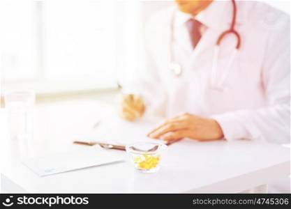 close up of male doctor writing prescription paper and capsules. male doctor with capsules