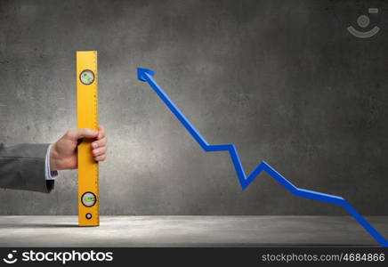 Close up of male hand measuring graph with ruler. How big the growth is