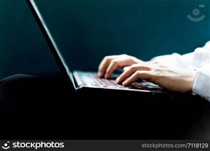 Close up of male hands with laptop computer typing on keyboard with copy space, business concept