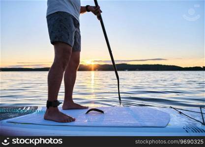 Close-up of male legs on a paddle board.. Male legs on a paddle board.
