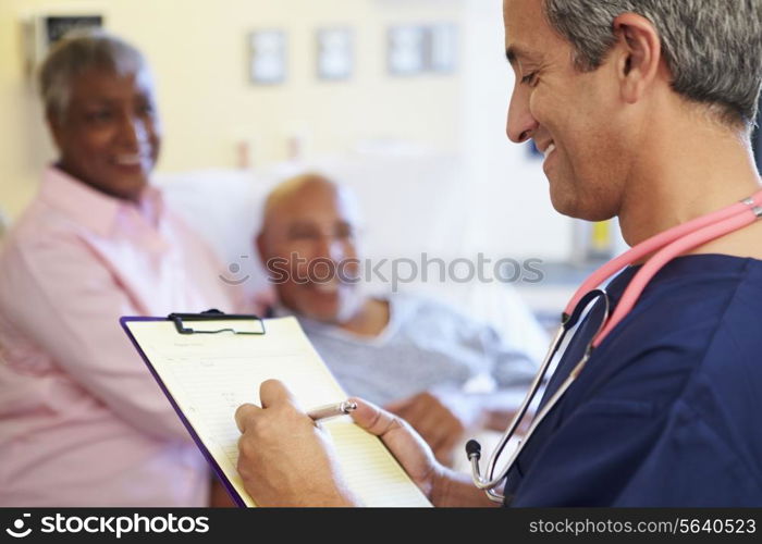 Close Up Of Male Nurse Updating Patient Notes