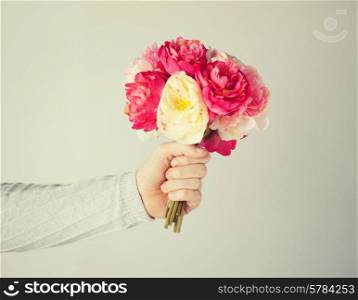 close up of man&#39;s hand giving bouquet of flowers.
