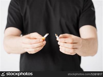 close up of man breaking the cigarette with hands