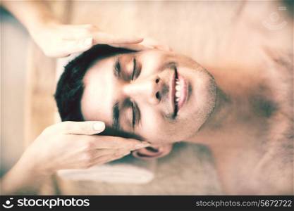 close up of man face in spa salon getting facial massage