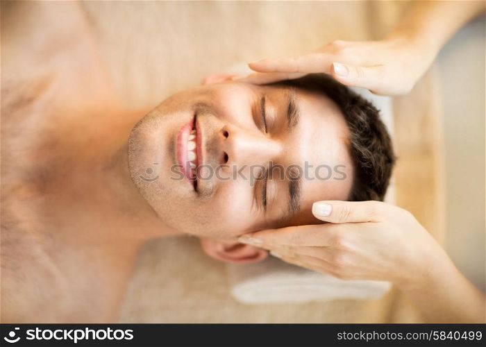 close up of man face in spa salon getting facial massage. man in spa