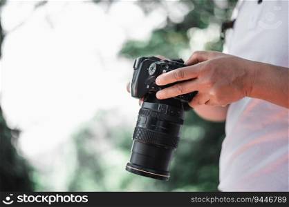 Close up of man hand checking a picture on camera at the park with copy space. Travel photographer. Vocation and holiday concept.