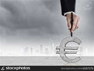 Close up of man hand drawing euro symbol. Money and currency