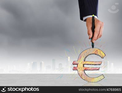 Close up of man hand drawing euro symbol. Money and currency