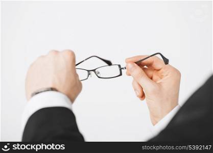 close up of man hands holding eyeglasses