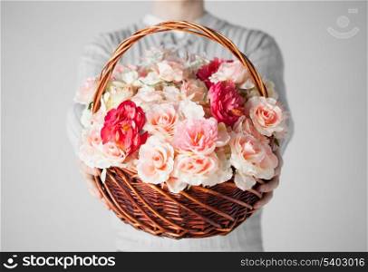 close up of man holding basket full of flowers.