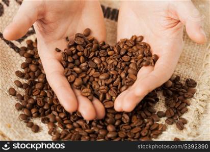 close up of man holding coffee beans