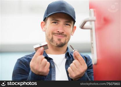 close-up of man holding door lock and key