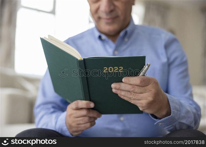 Close Up Of Man Holding New Year 2022 Diary At Home
