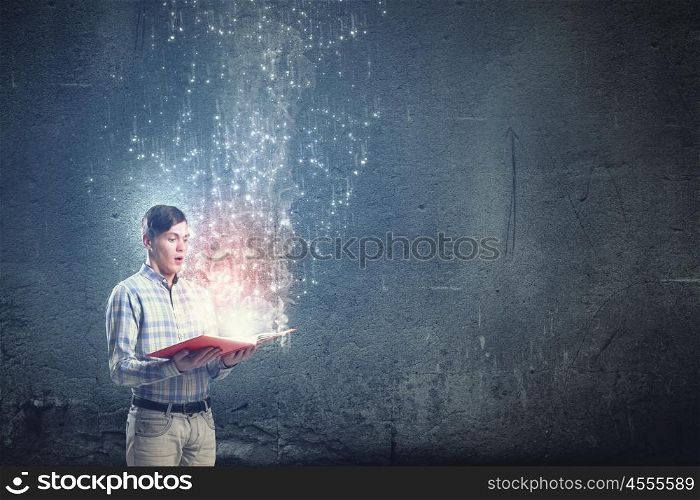 Close up of man holding opened book with flying out characters