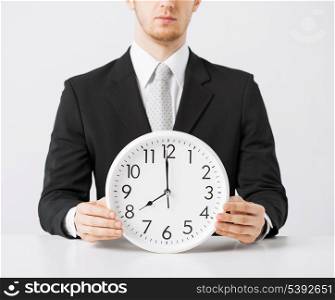 close up of man holding wall clock