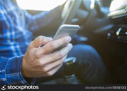 Close Up Of Man In Car Texting On Mobile Phone Whilst Driving