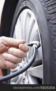 Close Up Of Man Inflating Car Tyre With Air Pressure Line