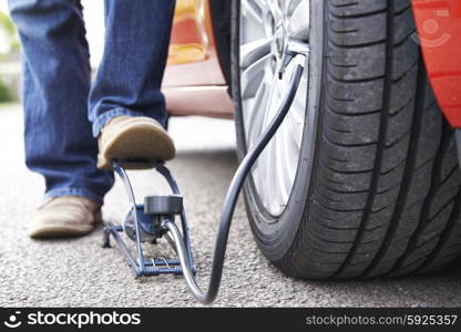 Close Up Of Man Inflating Car Tyre With Foot Pump