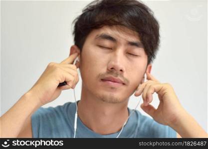 Close-up of man listening music with his smartphone over white background