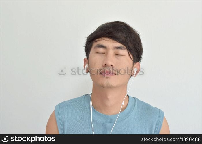 Close-up of man listening music with his smartphone over white background
