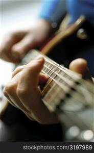 Close-up of man playing acoustic guitar