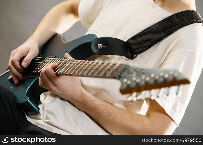 Close up of man playing on electric guitar during gig or at music studio. Musical instruments, passion and hobby concept.. Close up of man playing on electric guitar