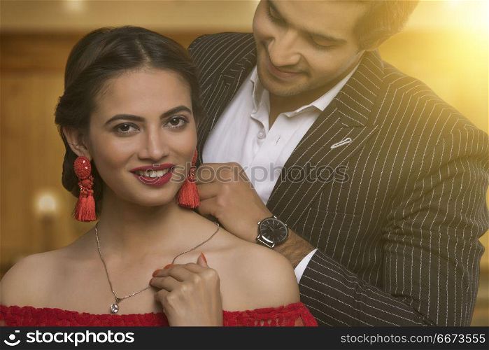 Close up of man putting necklace on his wife
