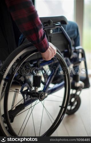 Close Up Of Man Sitting In Wheelchair At Home By Window