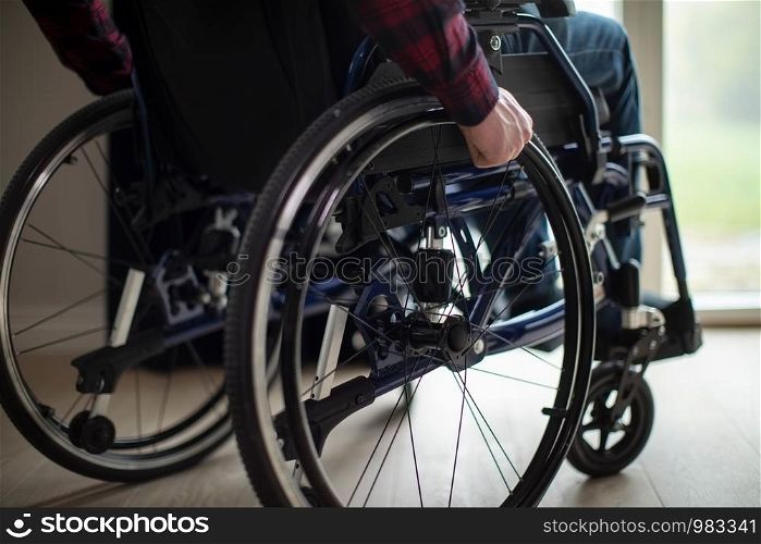 Close Up Of Man Sitting In Wheelchair At Home By Window