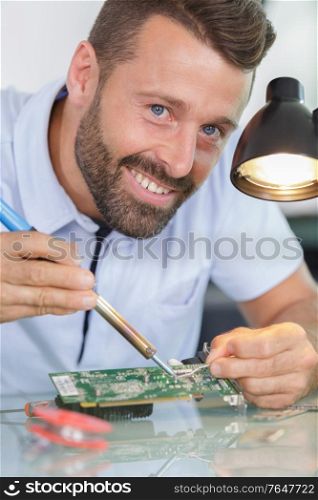 close up of man soldering computer component