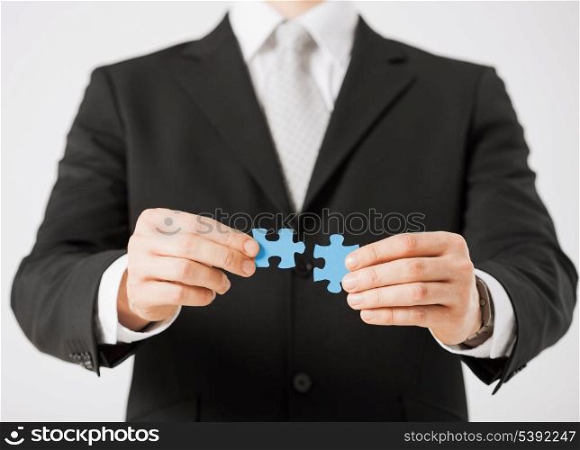 close up of man trying to connect puzzle pieces.