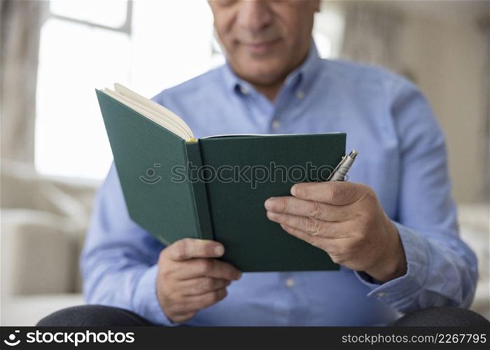 Close Up Of Man Writing In Diary Or Journal At Home
