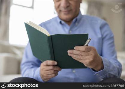 Close Up Of Man Writing In Diary Or Journal At Home