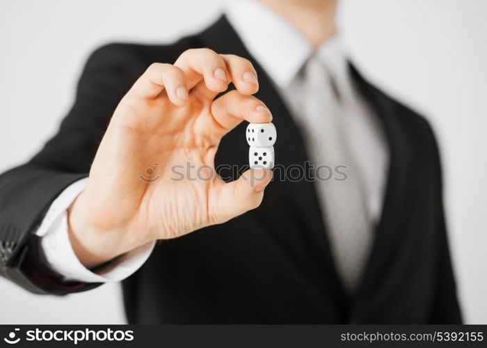 close up of mans hand holding white casino dice