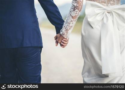 Close up of married couple holding hands in wedding day