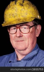 Close up of mature construction worker in eyeglasses and hard-hat