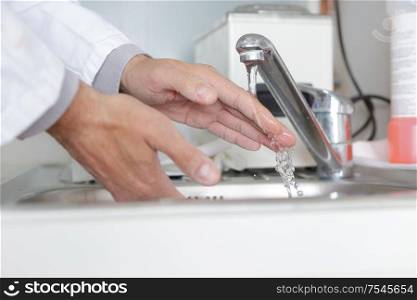 close up of medical staff washing hands