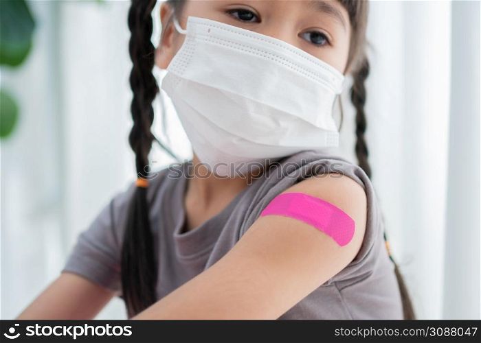Close-up of medicinal plaster after vaccinated in shoulder of Asian girl kids in hospital. Pediatrician makes vaccination for kids. Vaccination, immunization, disease prevention concept.