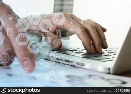 close up of Medicine doctor hand working with modern computer and medical diagram layers on wooden desk as medical concept