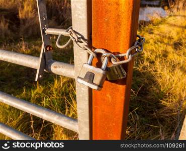 close up of metal padlock on gate and rusty fence; essex; england; uk